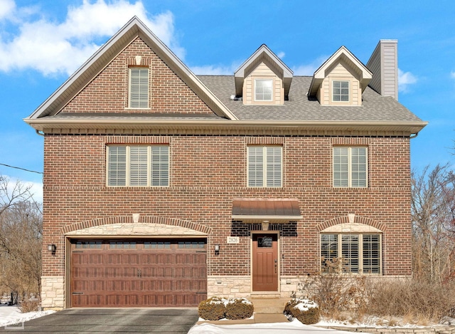 colonial inspired home with stone siding, brick siding, and driveway