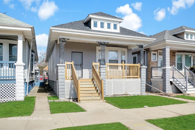 view of front of home featuring covered porch and a shingled roof