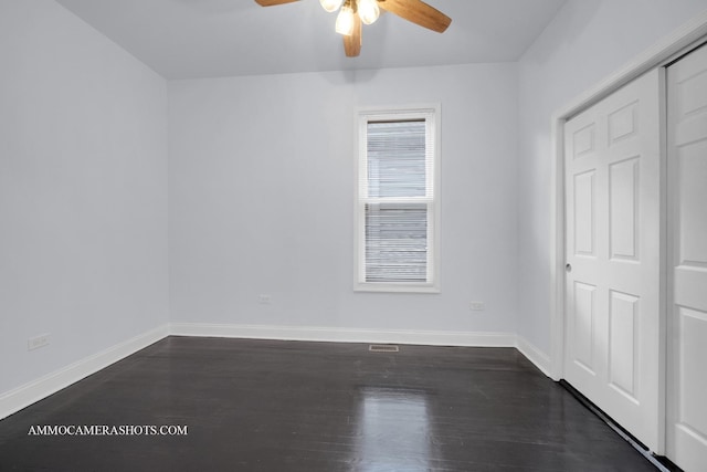 unfurnished bedroom featuring a ceiling fan, dark wood finished floors, and baseboards