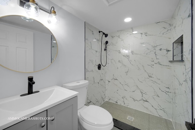 full bathroom featuring toilet, a marble finish shower, and vanity