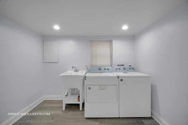 clothes washing area featuring light wood-type flooring, baseboards, washer and dryer, and recessed lighting