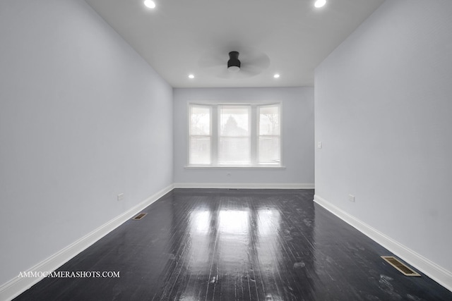 unfurnished room featuring recessed lighting, dark wood finished floors, visible vents, and baseboards