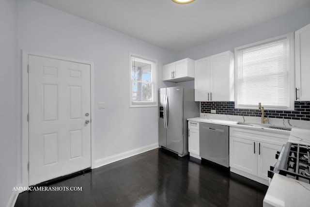 kitchen featuring backsplash, light stone counters, stainless steel appliances, and a sink