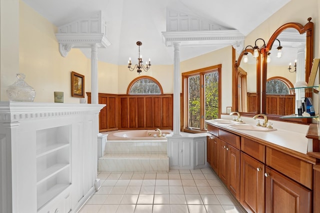 full bathroom with lofted ceiling, ornate columns, and a garden tub