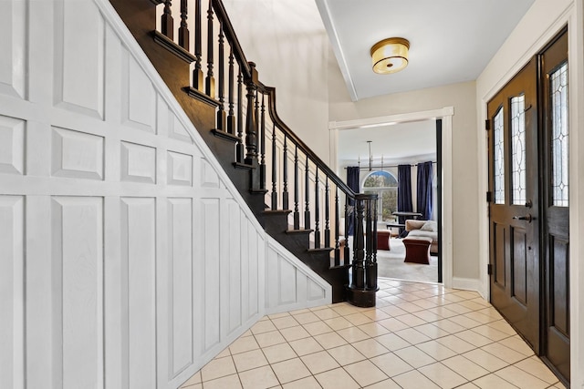 entrance foyer featuring light tile patterned floors and stairs