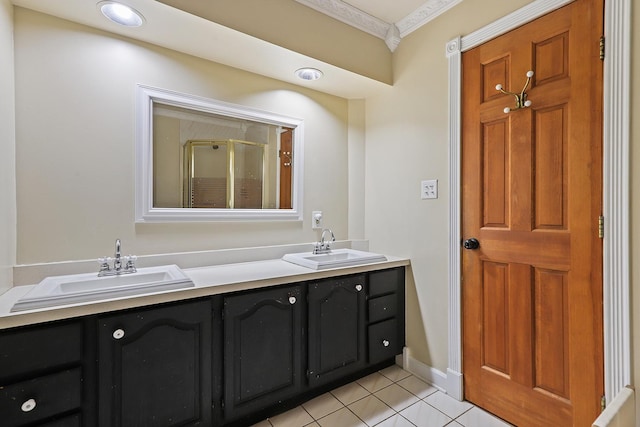 bathroom featuring double vanity, a stall shower, tile patterned flooring, and a sink