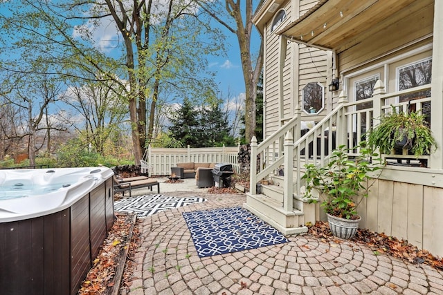 view of patio featuring area for grilling, outdoor lounge area, fence, and a hot tub