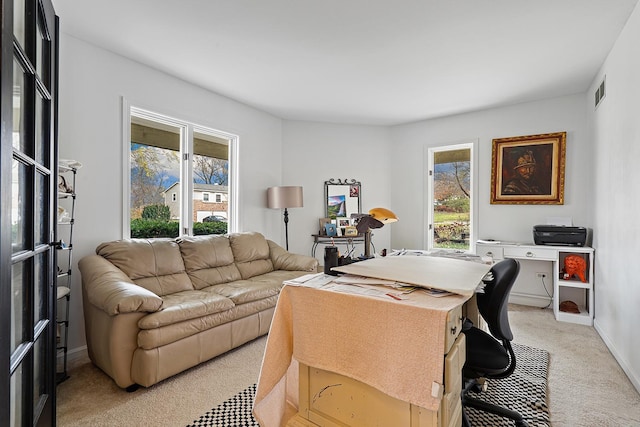 office space featuring light colored carpet, visible vents, and baseboards