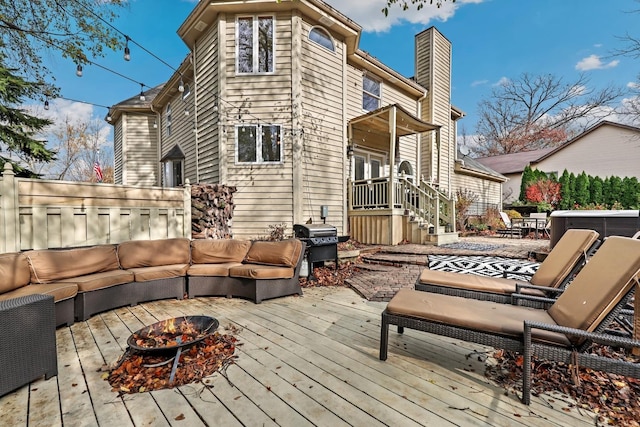 rear view of property with an outdoor living space with a fire pit and a wooden deck