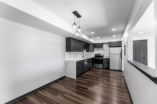 kitchen featuring dark wood-style flooring, tasteful backsplash, light countertops, appliances with stainless steel finishes, and a sink