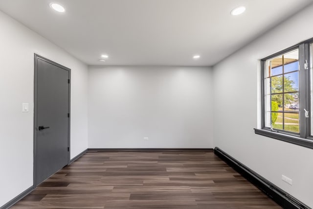 spare room with baseboards, dark wood finished floors, and recessed lighting