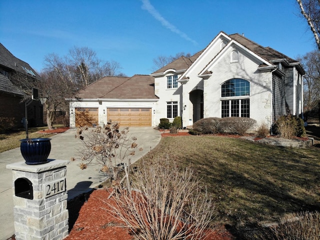 french country home with a garage, a front lawn, brick siding, and driveway