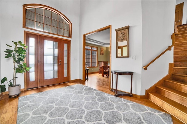 entryway featuring a high ceiling, wood finished floors, and a healthy amount of sunlight