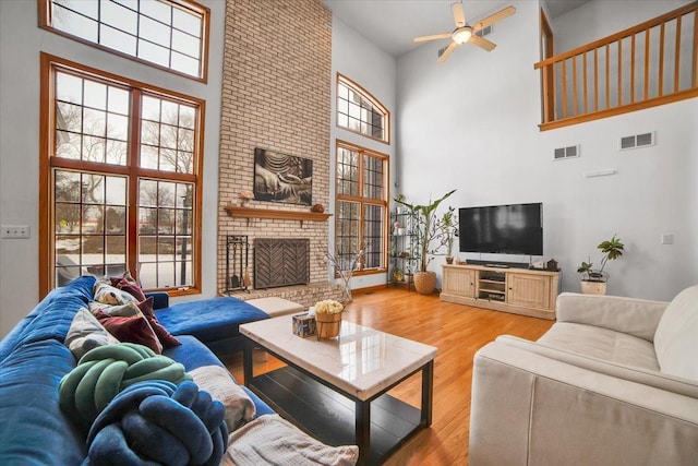 living room with visible vents, wood finished floors, and a fireplace