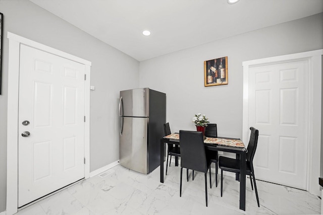 dining space featuring recessed lighting, marble finish floor, and baseboards