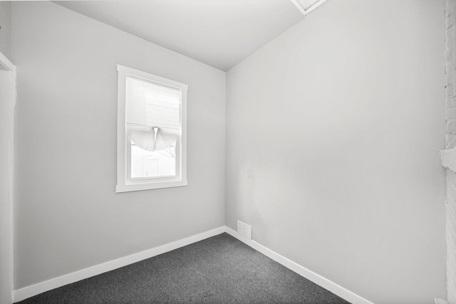 empty room featuring carpet and baseboards