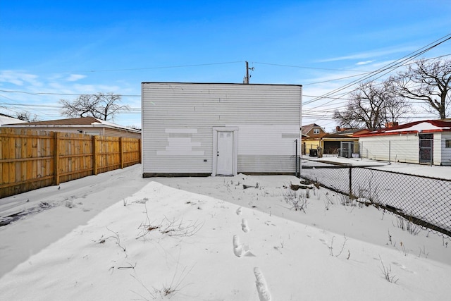 snow covered back of property featuring fence private yard