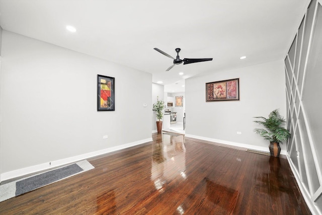 spare room featuring dark wood-type flooring, recessed lighting, baseboards, and a ceiling fan