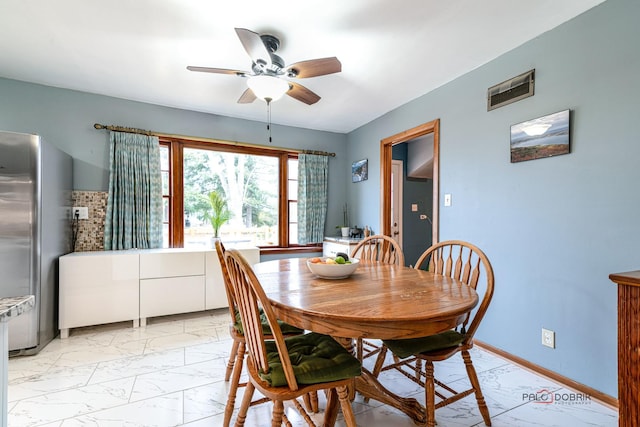 dining space with marble finish floor, visible vents, ceiling fan, and baseboards