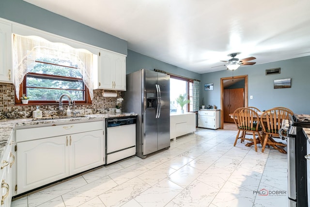 kitchen featuring a sink, white cabinets, marble finish floor, appliances with stainless steel finishes, and backsplash