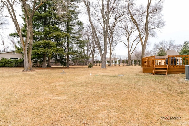 view of yard featuring central AC unit and a wooden deck