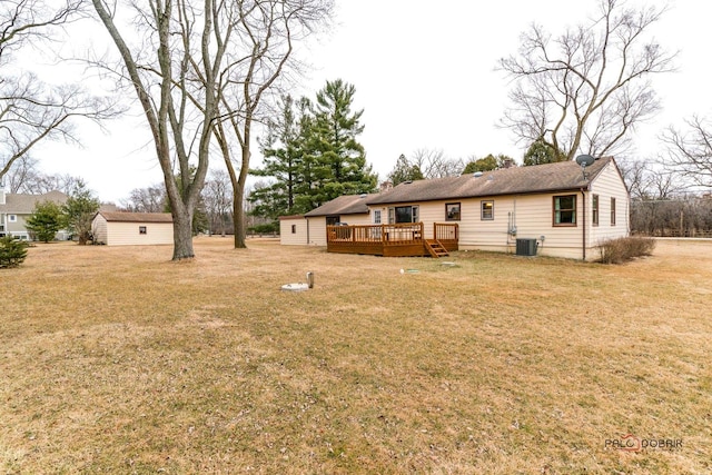 back of house with a yard, an outdoor structure, a deck, and central air condition unit