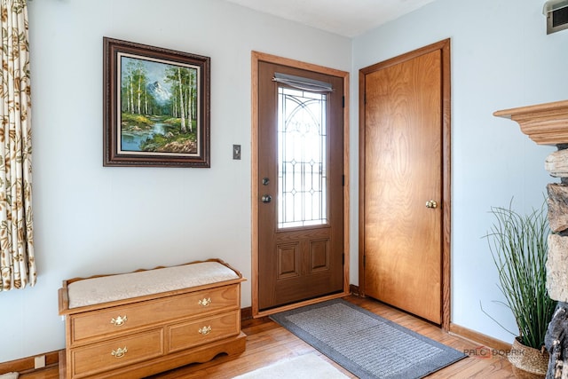 foyer featuring light wood-style flooring and baseboards