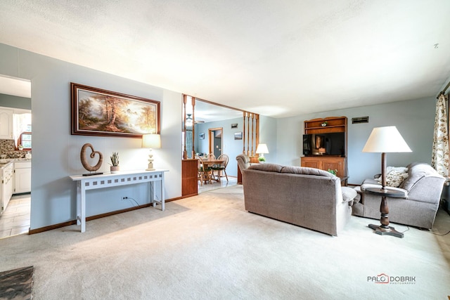 living area featuring baseboards and light colored carpet