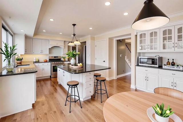 6 Robin Hood Ct, Lincolnshire, IL 60069 - kitchen featuring light wood-style flooring, a center island, a sink, a kitchen bar, and appliances with stainless steel finishes