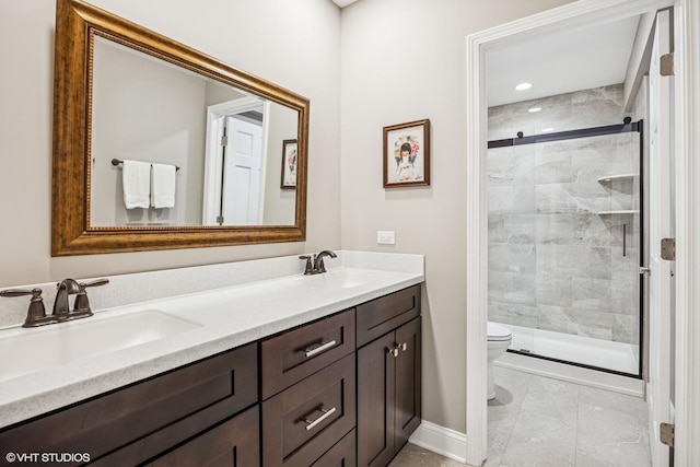 bathroom with toilet, a stall shower, double vanity, and a sink