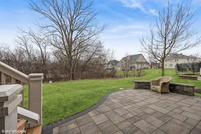 view of yard with a trampoline, a residential view, and a patio