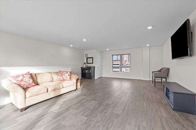 living room featuring recessed lighting, baseboards, and wood finished floors