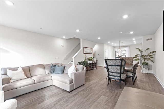 living room featuring recessed lighting, wood finished floors, visible vents, baseboards, and stairway