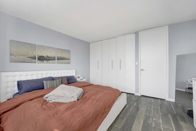 bedroom with dark wood-style floors and baseboards