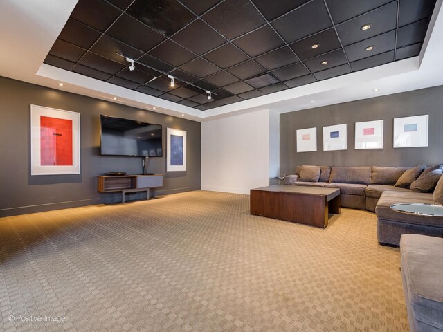 living area with a tray ceiling, recessed lighting, light carpet, track lighting, and baseboards