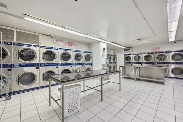 shared laundry area featuring light tile patterned floors, separate washer and dryer, visible vents, and stacked washer and clothes dryer