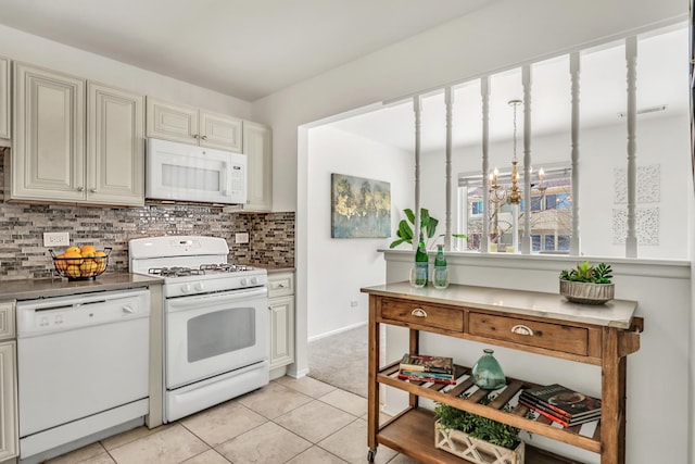 kitchen featuring light tile patterned floors, a notable chandelier, white appliances, cream cabinetry, and tasteful backsplash