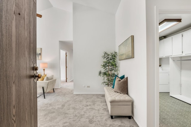 sitting room featuring baseboards, high vaulted ceiling, washer / clothes dryer, and light colored carpet