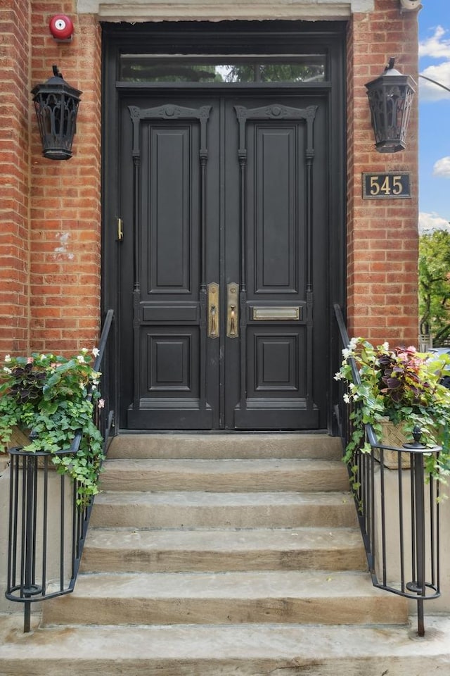 entrance to property featuring brick siding