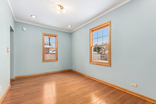 unfurnished room featuring baseboards, light wood finished floors, and crown molding