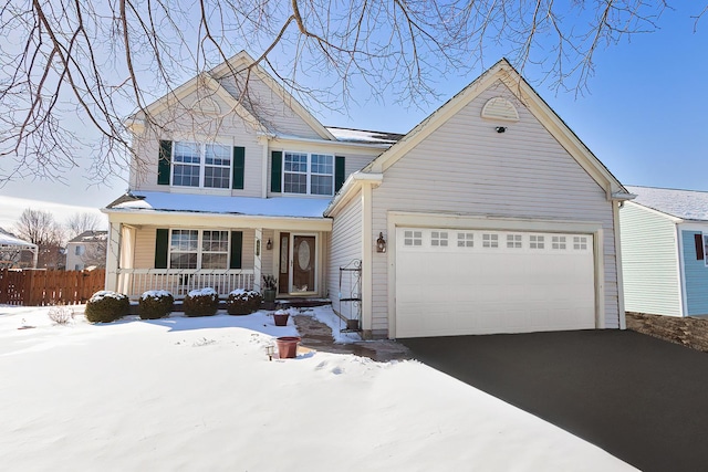 traditional-style house featuring covered porch, driveway, and an attached garage