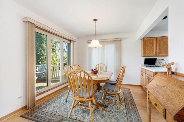 dining space with light wood-style flooring and baseboards