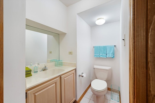 half bath with toilet, tile patterned flooring, baseboards, and vanity