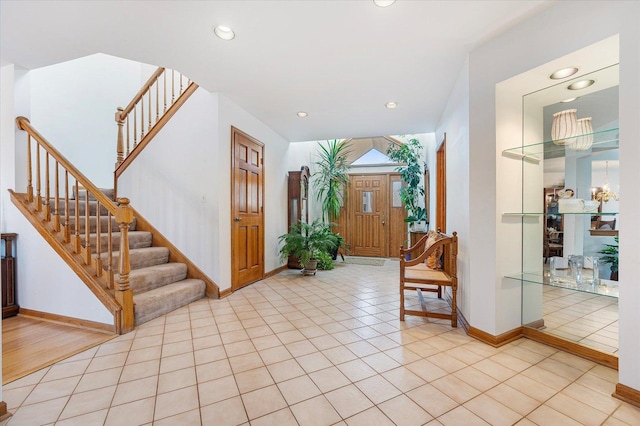 foyer entrance with recessed lighting, light tile patterned flooring, stairway, and baseboards