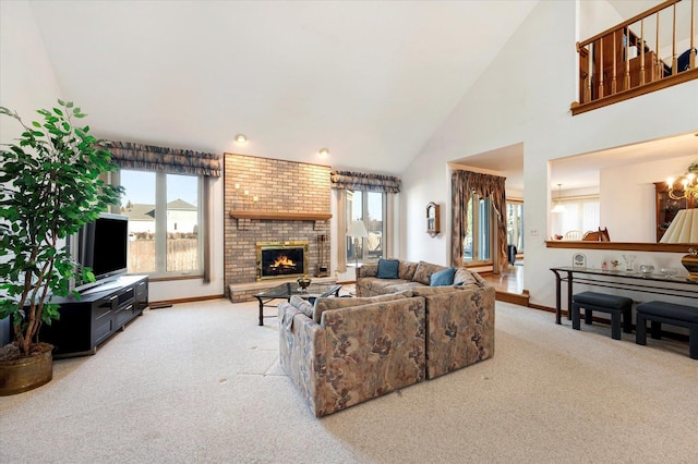 carpeted living area with a brick fireplace, plenty of natural light, high vaulted ceiling, and a notable chandelier