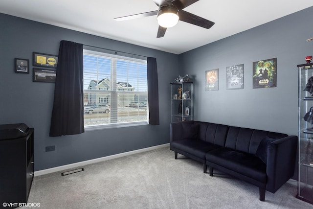 sitting room featuring baseboards, ceiling fan, visible vents, and light colored carpet