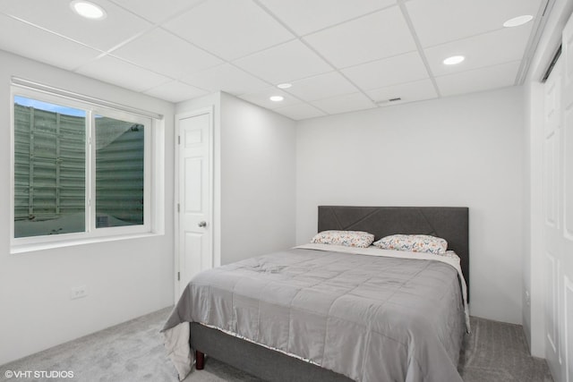 carpeted bedroom with a drop ceiling and recessed lighting