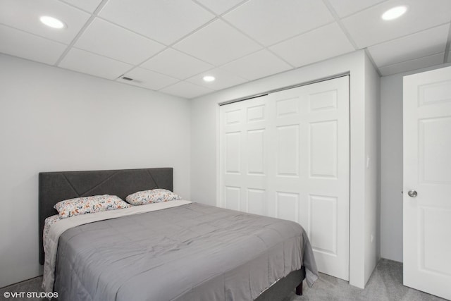 carpeted bedroom featuring recessed lighting, a closet, and a drop ceiling