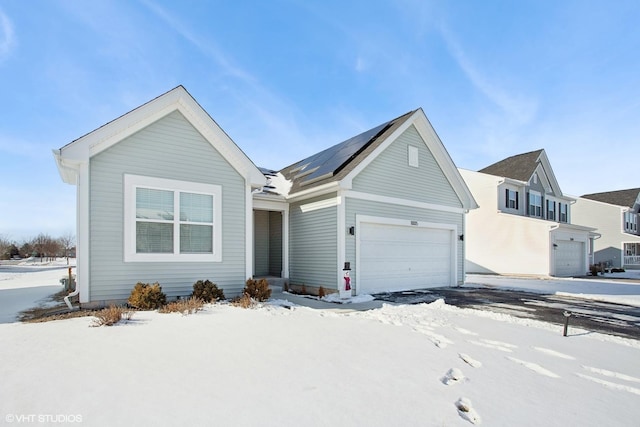 view of front of home with solar panels and an attached garage