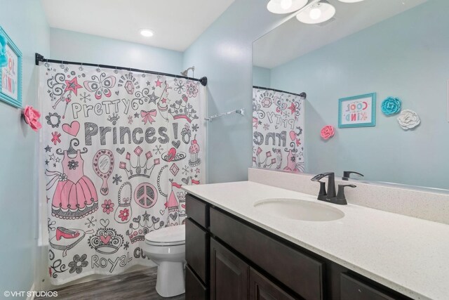 full bathroom featuring toilet, wood finished floors, vanity, and shower / tub combo with curtain